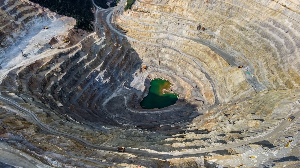 Massive Open-Pit Mining Operation Showing Stepped Terraces And Heavy-Duty Trucks; Mining Truck Muffler Use Is Essential For Environmental Compliance In Such Large-Scale Sites.