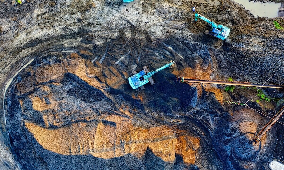 Top-Down View Of Excavators At A Large Open-Pit Mine Site Moving Gravel And Minerals In Challenging Working Conditions