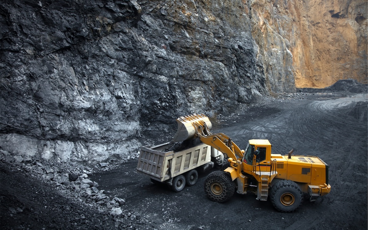 Heavy Machinery Operating In A Deep Mine, Loading Rock Into A Dump Truck Equipped With Heavy Duty Parts